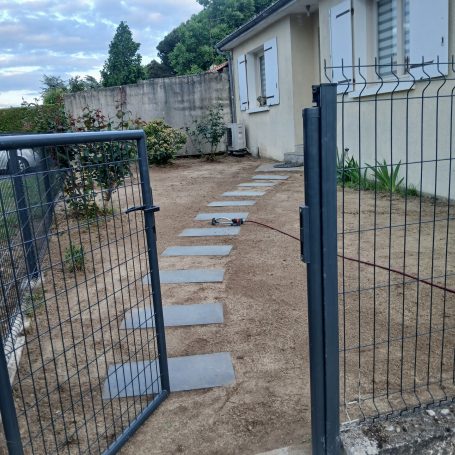 Pose d'une clôture et aménagement piéton et engazonnement.